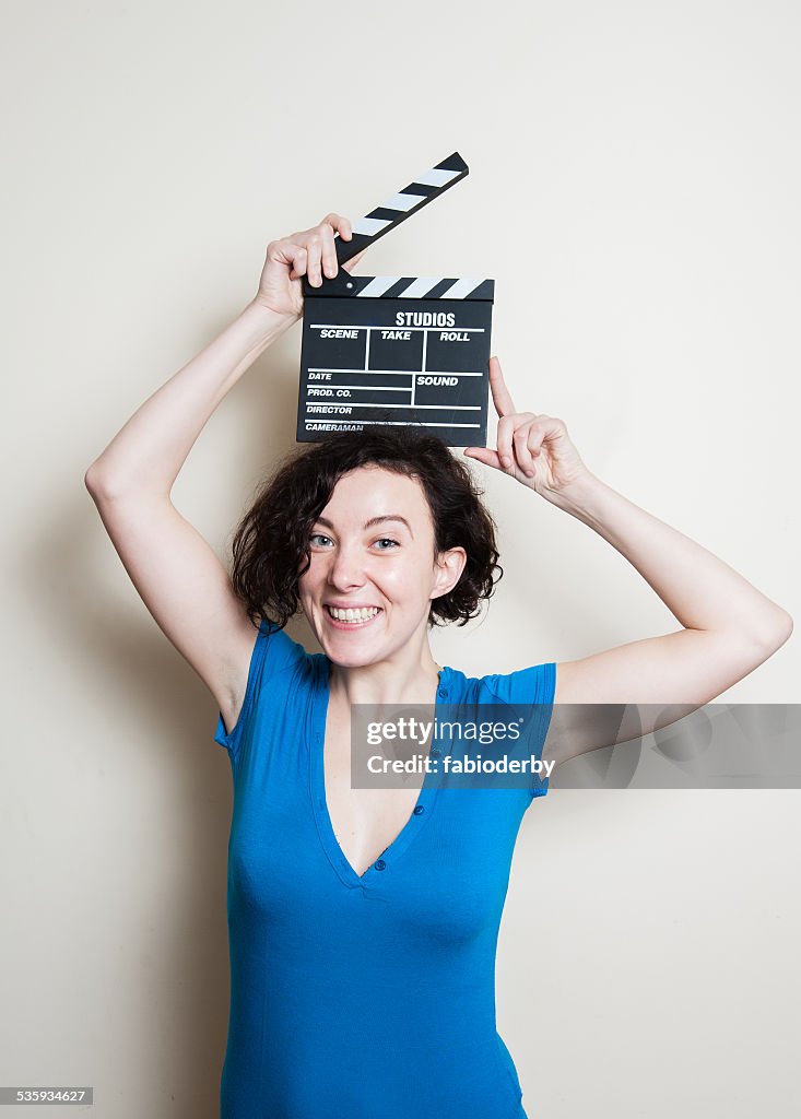 Smiling girl with movie clapper on white background