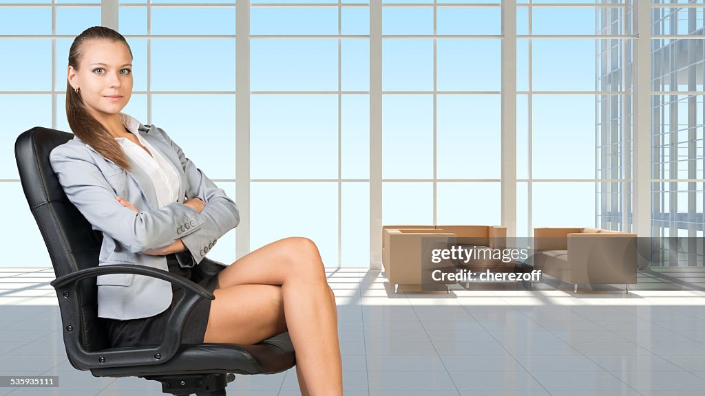 Femme d'affaires dans les écouteurs, intérieur avec mur transparent