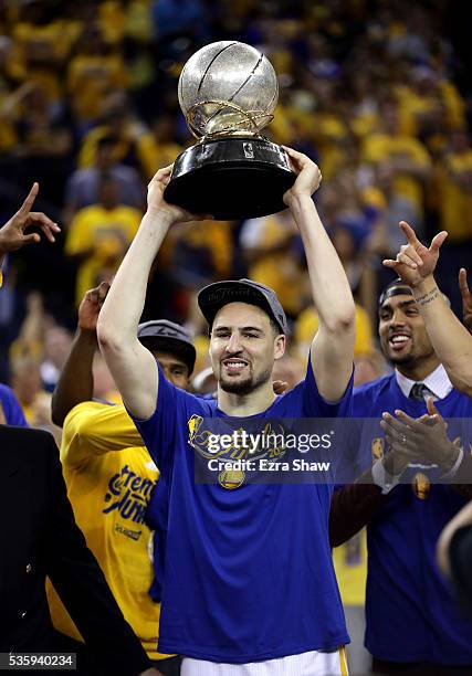 Klay Thompson of the Golden State Warriors holds up the Western Conference Trophy after they beat the Oklahoma City Thunder in Game Seven of the...