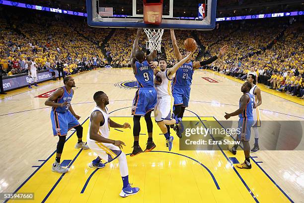 Klay Thompson of the Golden State Warriors goes up for a shot against Serge Ibaka and Andre Roberson of the Oklahoma City Thunder in the first half...