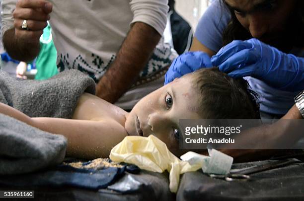Syrian child receives treatment at a hospital after the Russian airstrikes targeted the National Hospital in Idlib, Syria on May 31, 2016.