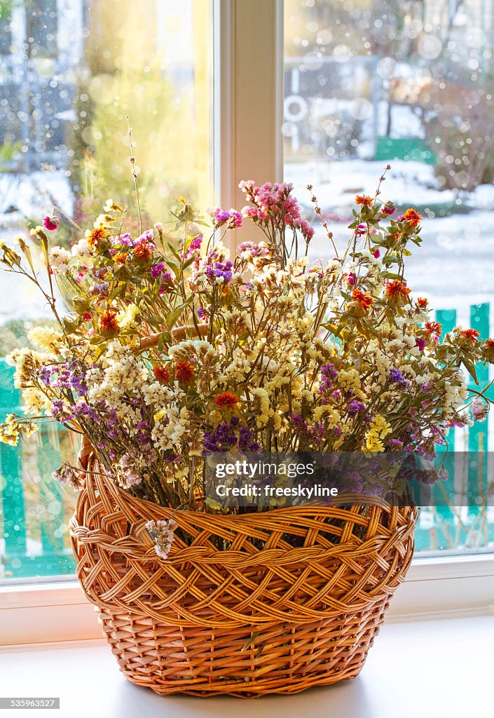 Dried flowers in einem Korb auf dem Fenster