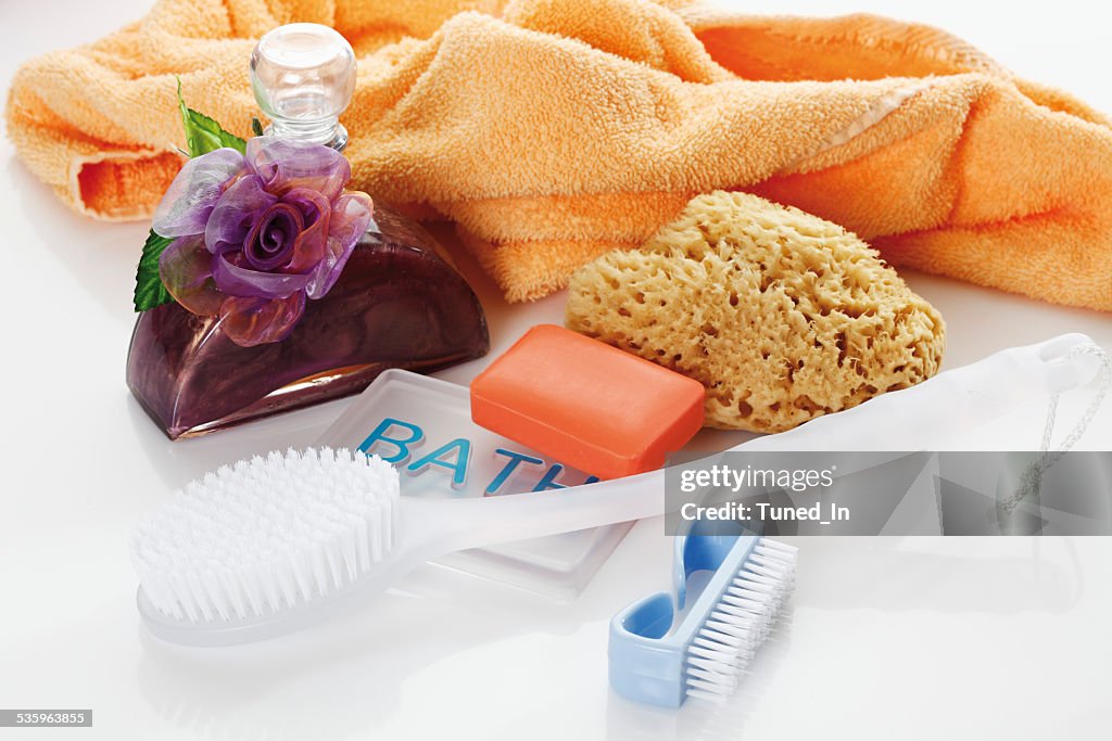 Sponge, soap and bath oil against white background