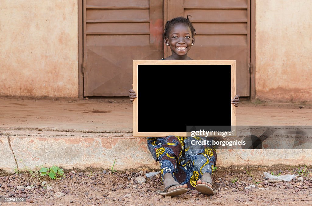 Lächelnd glückliche afrikanische Schulmädchen-Holding Tafel sitzen in der Schule