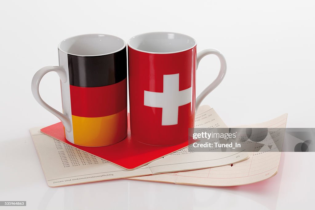 Swiss and german flag cups with bank book