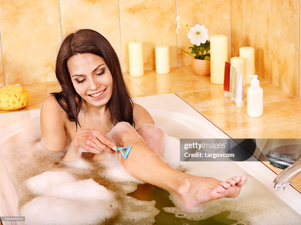 Le gambe di donna da barba nella vasca da bagno