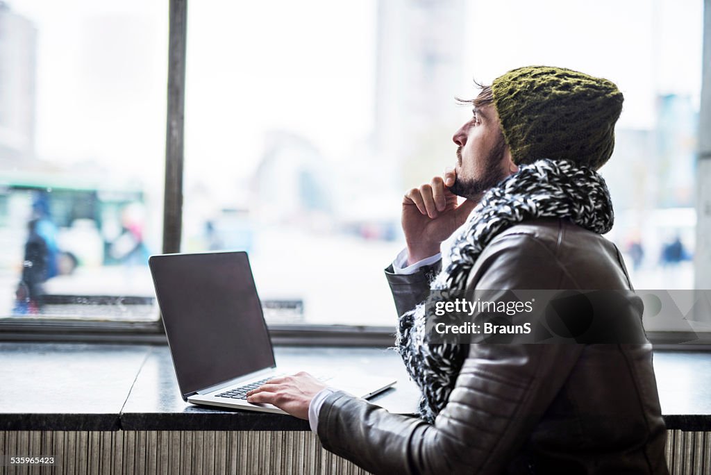 Pensive man using laptop.