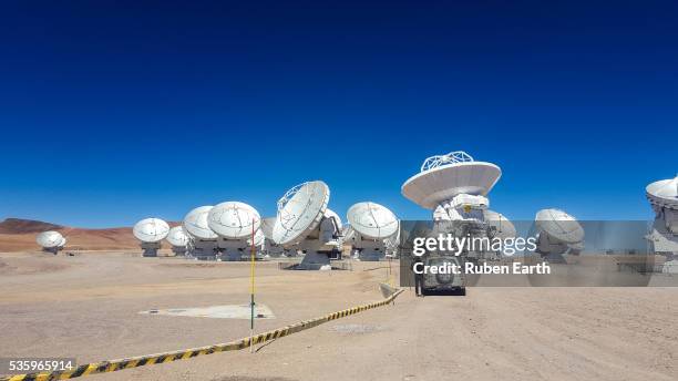 a woman and a car looking at the radio telescopes - atacama large millimeter array stock pictures, royalty-free photos & images