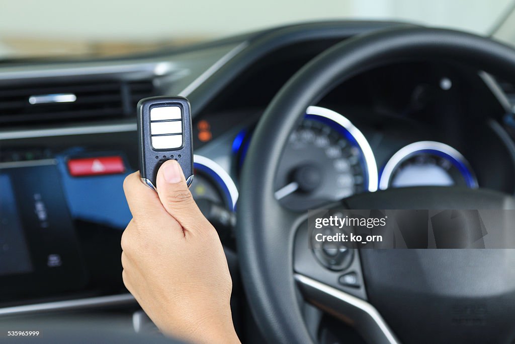 Business woman show remote key in modern vehicle car.