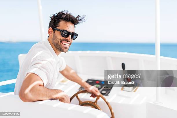 young man driving a boat. - yachting stockfoto's en -beelden