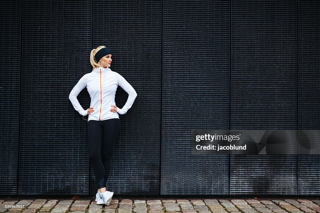 Determined woman resting after jogging in the city