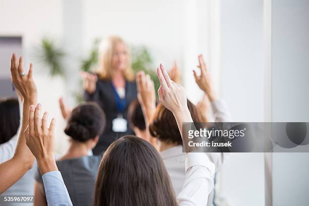 group of women voting during seminar - armen omhoog stockfoto's en -beelden