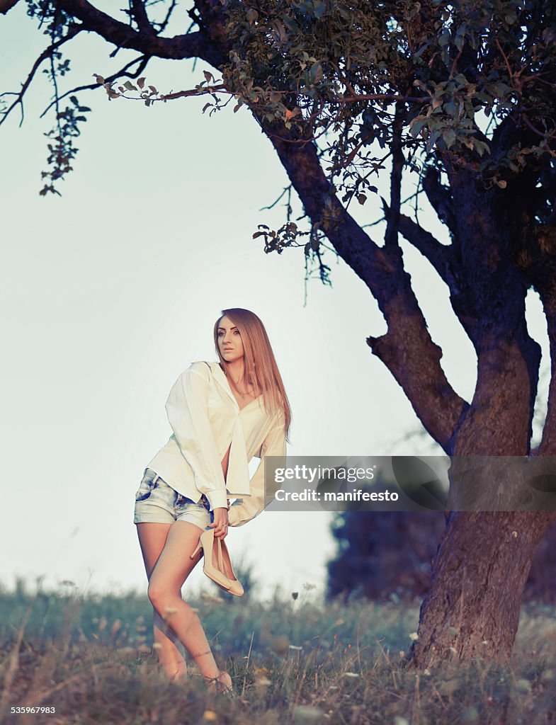 Pretty woman posing outside in summer garden.