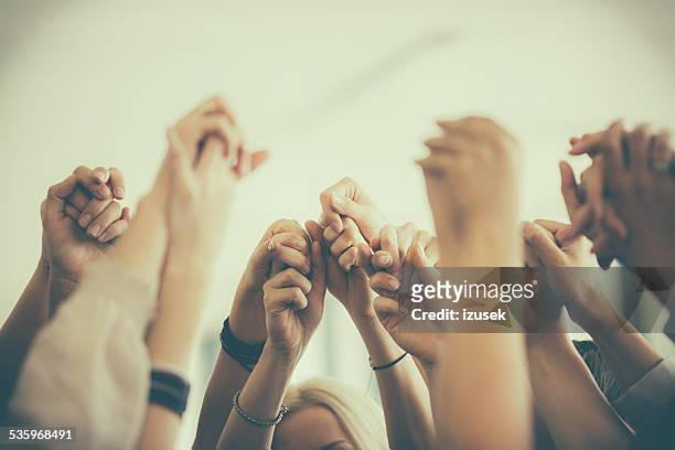 grupo de mulheres segurando as mãos. unidade conceito de - uniforme - fotografias e filmes do acervo