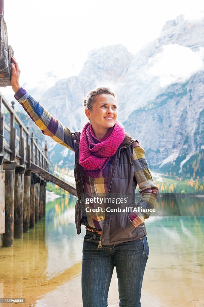 Happy young woman on lake braies in south tyrol, italy