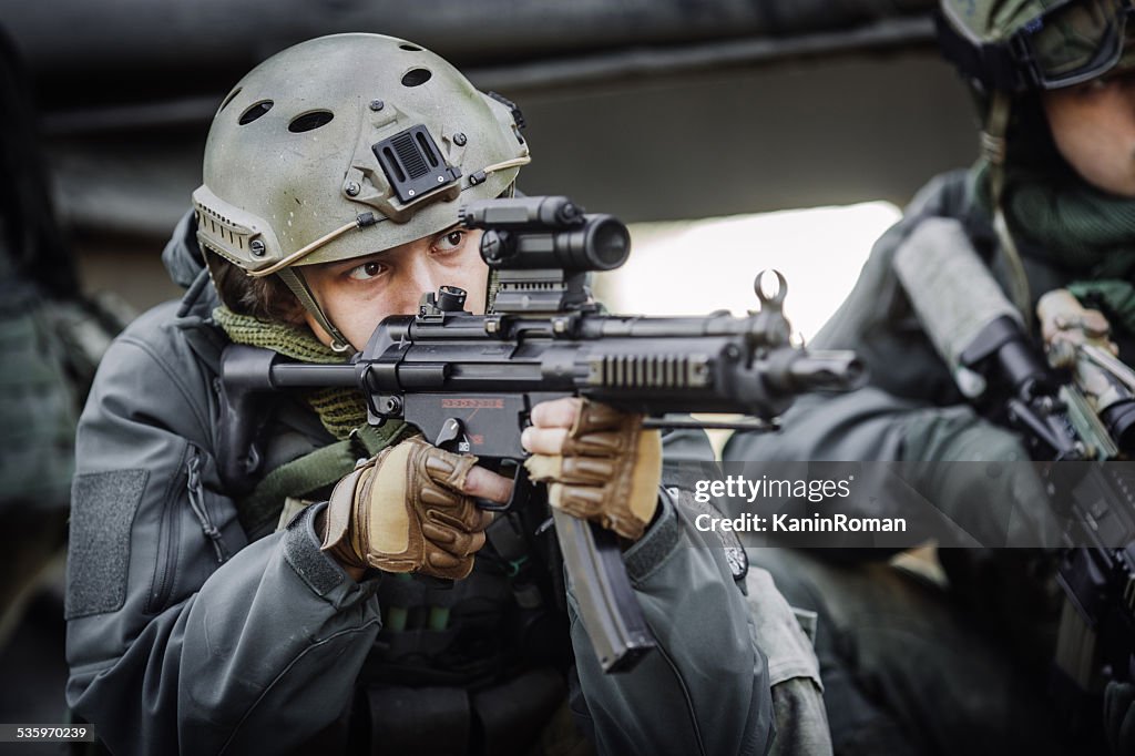 Military soldier shooting an assault rifle