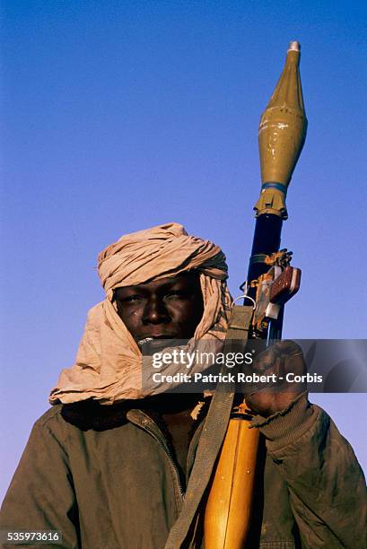 Soldier with the Forces Armees Nationales Chadiennes , or National Army of Chad, smokes a cigarette while standing guard with a rocket launcher at...