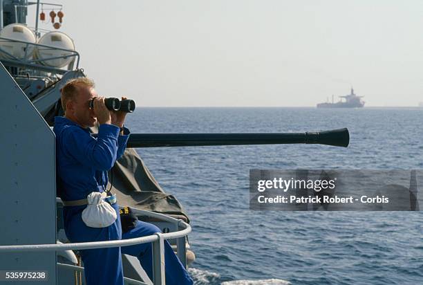 Soldier aboard the French gunboat Doudart de Lagree scans the horizon with binoculars while patrolling the Persian Gulf during the Iran-Iraq War....