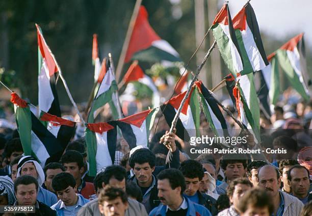 During a funeral procession, mourners carrying Palestinian Liberation Organization flags protest the death of a Palestinian killed during the...