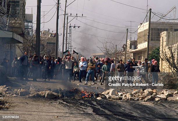 Palestinian demonstrators throw stones at Israeli soldiers during a protest in the streets of Beit Omar. Violence broke out after rebel Israeli and...