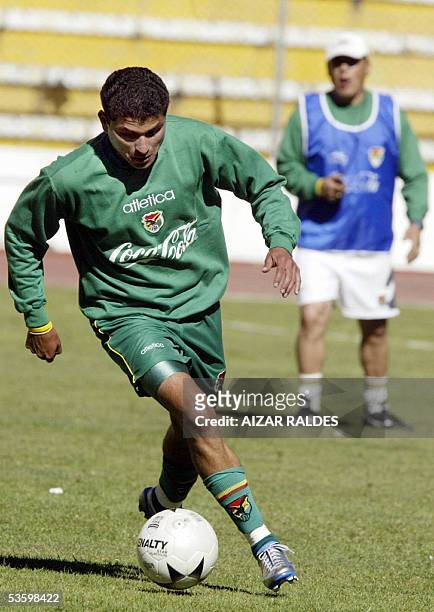 Joaquin Botero de la seleccion boliviana de futbol se lleva el balon observado por el asistente tecnico Pedro Rioja en un entrenamiento el 31 de...