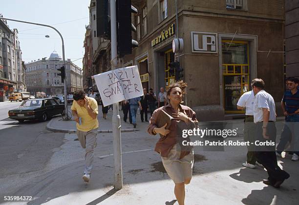 Bosnian civilians flee a sniper's gunshots on the streets of Sarajevo. Thousands of Bosnian and Serb civilians were victims of the Yugoslavian Civil...