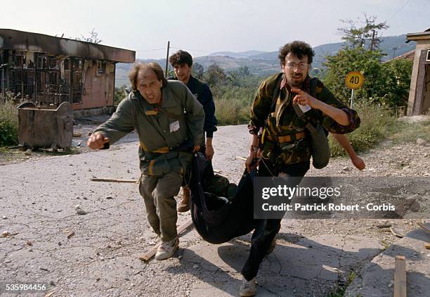 Unit of Muslim soldiers tries to attack Serb defenses surrounding the city. Bosnian soldiers help a Bosnian commanding officer who was seriously...