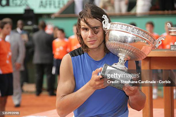 Rafael Nadal poses with the trophy after the final of the 2006 French Open at Roland Garros against Roger Federer . Nadal won 1-6,6-1,6-4,7-6 .