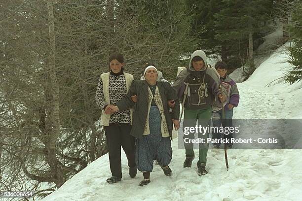 Kosovo Albanian refugees cross the Kosovo-Montenegro border escorted by KLA soldiers.