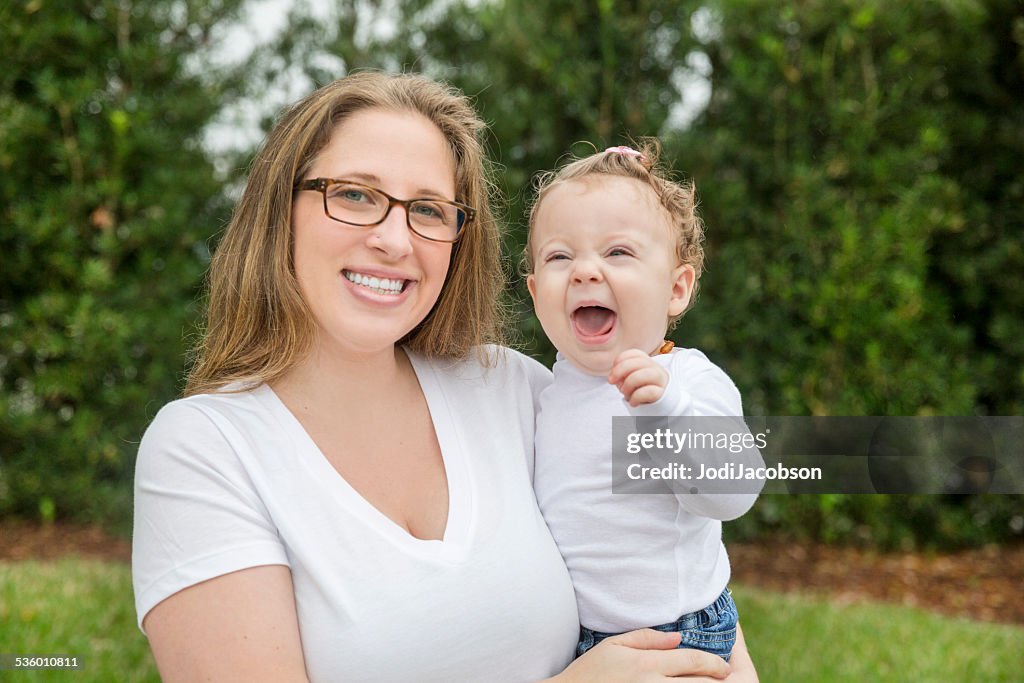 Caucasian mother holding her happy baby daughter