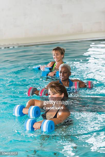 multiracial mature women in water aerobics class - aquarobics stockfoto's en -beelden