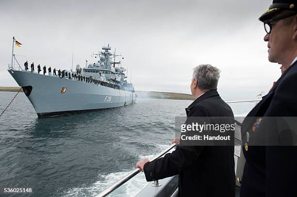 In this handout photo provided by the German Government Press Office , German President Joachim Gauck looks at the navy soldiers of German frigate of...