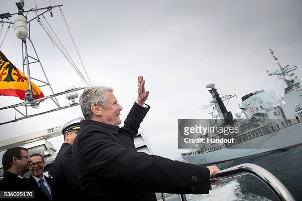 In this handout photo provided by the German Government Press Office , German President Joachim Gauck waves as the HMS Kent passes during the 100th...