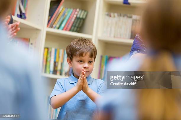 young school boy with his hands clasped - religion bildbanksfoton och bilder