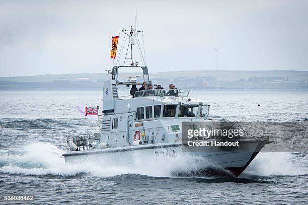 In this handout photo provided by the German Government Press Office , German President Joachim Gauck travels with a British navy boat back to Scapa...