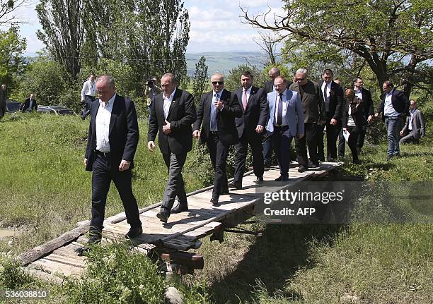 Slovakian President Andrej Kiska followed by Georgia's President Georgy Margvelashvili, cross a wetland near the village of Khurvaleti, Georgia,...