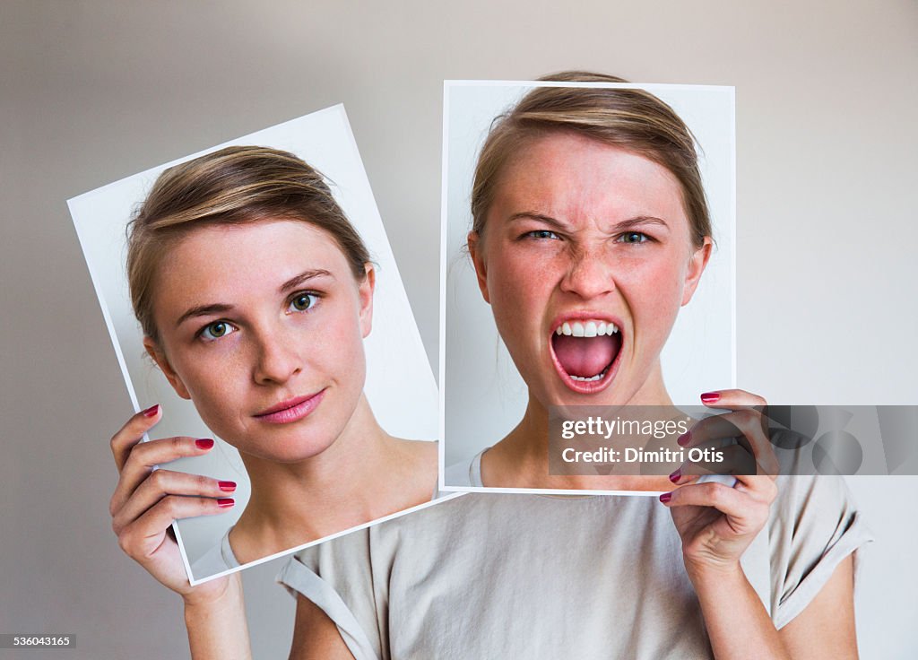 Woman holding happy and angry portraits