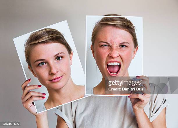 woman holding happy and angry portraits - persona imagens e fotografias de stock