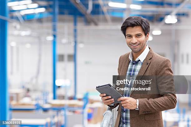 glückliche junge geschäftsmann mit digitalen tablet im warehouse - mann berater stock-fotos und bilder