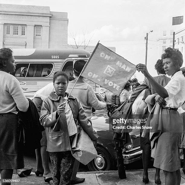 Young Civil Rights activist holds a flag on the steps of the Dexter Avenue Baptist Church on the day before the Selma to Montogmery March arrived at...