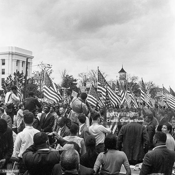 View down Dexter Avenue across press tables and a sea of marchers and American flags at the end of the Selma to Montgomery March, Montgomery,...