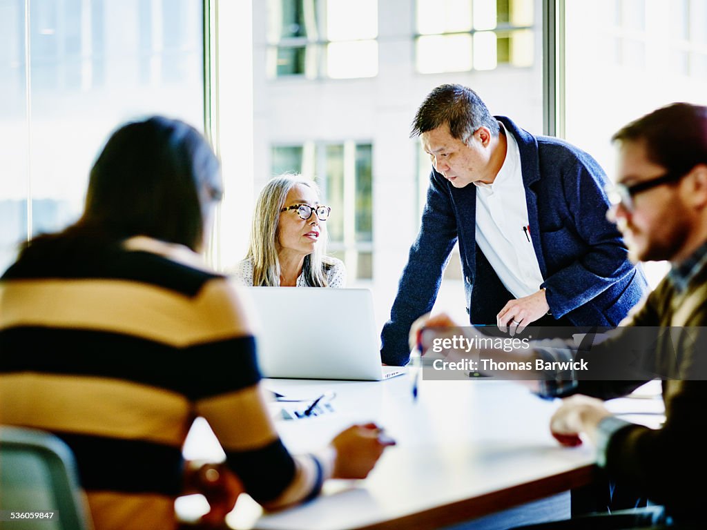 Business partners discussing project on laptop