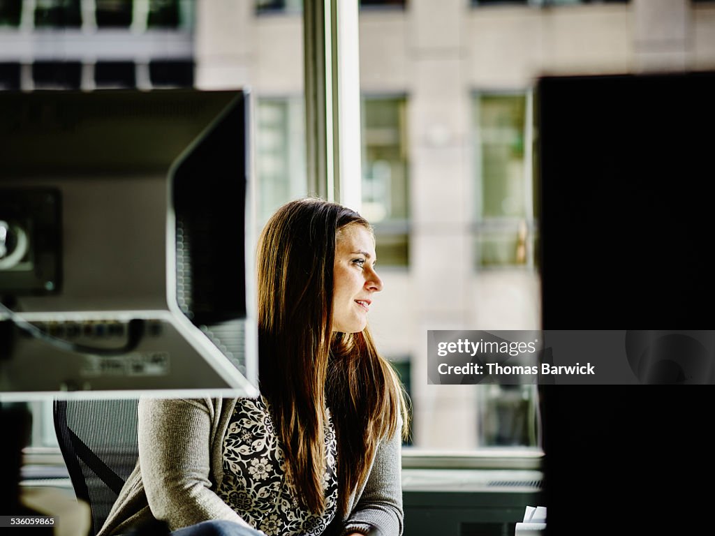 Smiling businesswoman at workstation in office