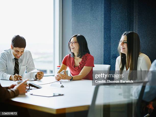 laughing businesspeople meeting in conference room - asian young executive laughing office bildbanksfoton och bilder