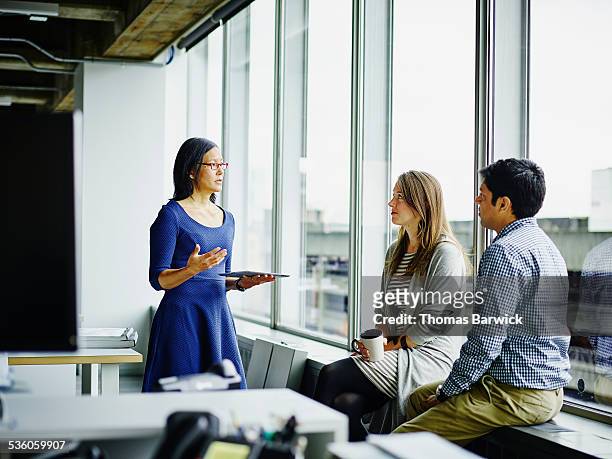 businesswoman leading discussion with colleagues - weibliche führungskraft stock-fotos und bilder