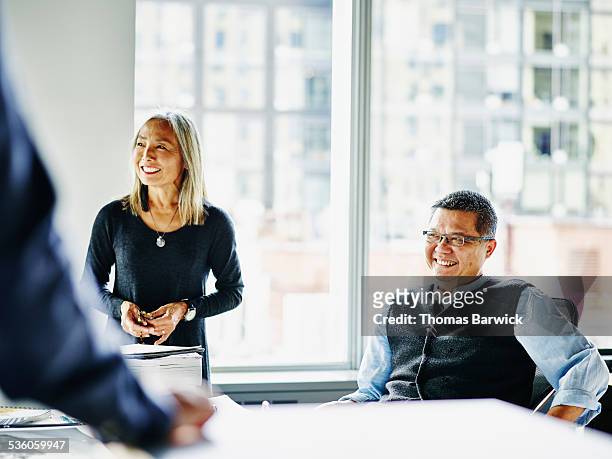 Smiling mature architects laughing during meeting