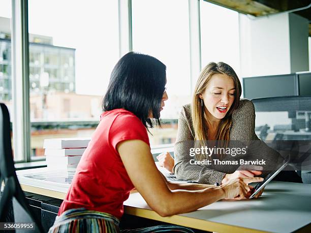 businesswomen discussing project on digital tablet - tablet 2 personen beratung stock-fotos und bilder