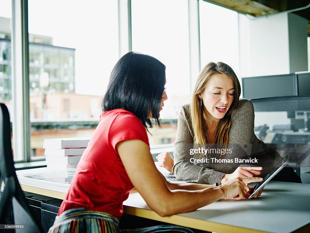 Businesswomen discussing project on digital tablet