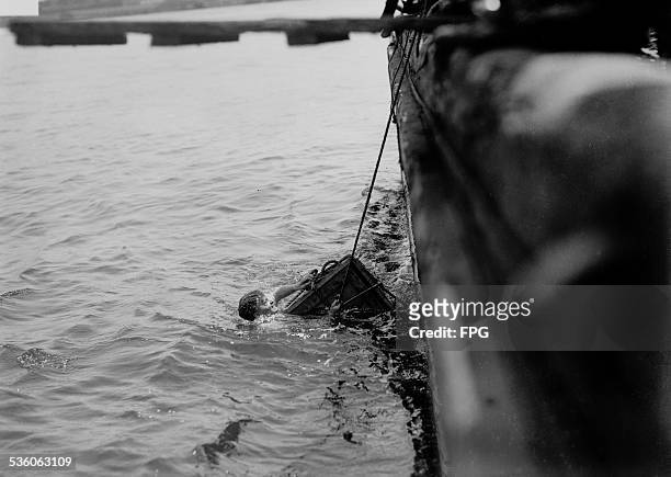 Illusionist and escape artist Harry Houdini is submerged in the East River in a crate, New York City, 7th July 1912. He escaped in just under a...