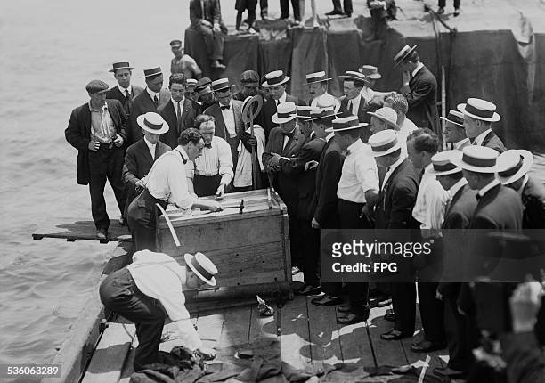 Illusionist and escape artist Harry Houdini is submerged in the East River in a crate, New York City, 7th July 1912. He escaped in just under a...